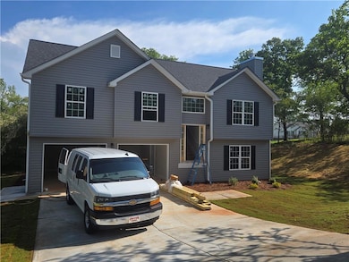 Bi-level home featuring concrete driveway, an atta