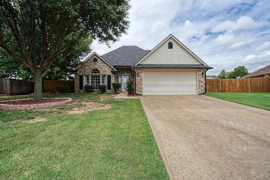 Traditional-style home with concrete driveway, a garage, brick siding, and roof with shingles