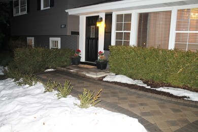 Inviting entrance with stone driveway, walkways, a