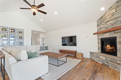 Living area featuring high vaulted ceiling, hardwood / wood-style floors, recessed lighting, a fireplace, and ceiling fan
