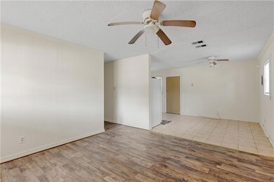 Empty room featuring a textured ceiling, visible v
