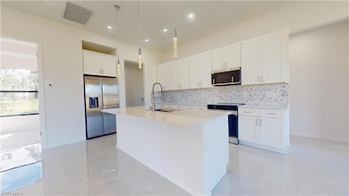 Kitchen with visible vents, an island with sink, d