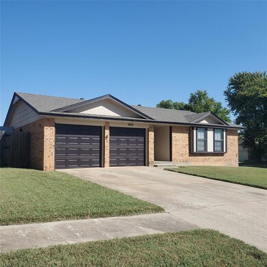 Ranch-style home with a garage and a front lawn
