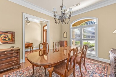Wood floors from the entry flow into the formal di