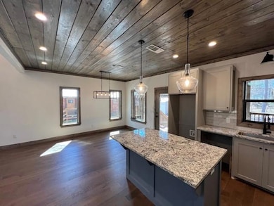 Kitchen featuring a sink, light stone counters, de