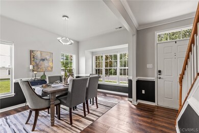 Dining area featuring crown molding and dark hardw