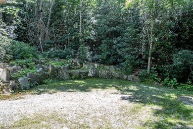 Flat parking area at end of driveway with boulder 