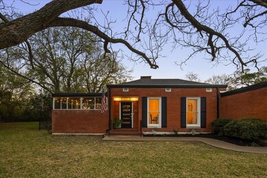 Back of property featuring a lawn, a sunroom, and
