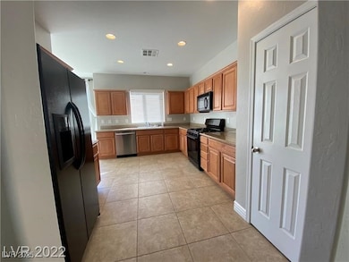 Kitchen featuring black appliances, light tile pat