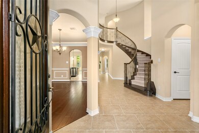 As your guests enter that are greeted by the soaring 20 foot ceilings, arches and crown molding encased columns that delineate the dining room from this grand foyer. The sweeping staircase is lined with ornate wrought iron spindles and richly stained handrails, wooden tread trim and handrails.