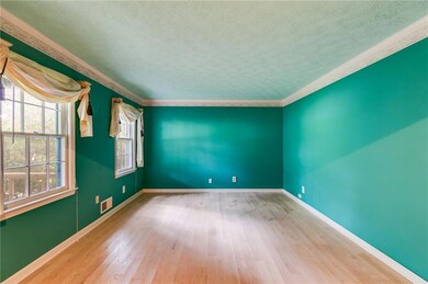 Empty room with wood finished floors, ornamental molding, and a textured ceiling