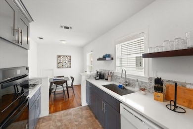 Galley kitchen with gas stove and breakfast area.