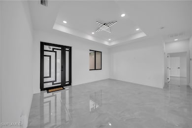 Spare room with marble tiled floors, a tray ceilin