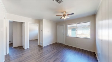 Empty room with wood finished floors, visible vent