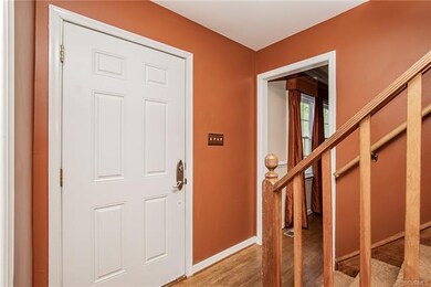 The foyer and carpeted staircase that leads to fou