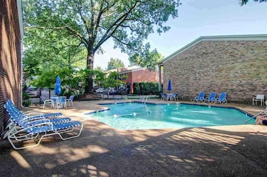 Community pool featuring a patio area and fence