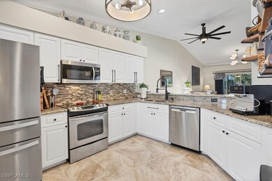 Kitchen featuring appliances with stainless steel finishes, a sink, backsplash, a ceiling fan, and ornamental molding