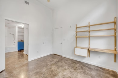 Spare room with finished concrete flooring, baseb