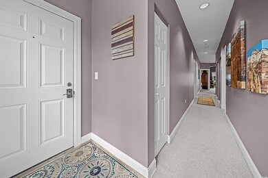 Corridor featuring light colored carpet