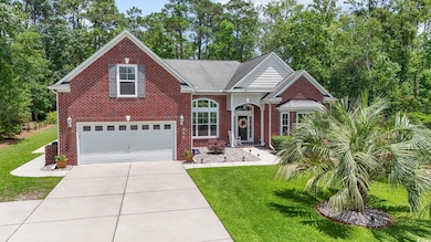 Traditional-style house featuring a garage, brick siding, a front lawn, and concrete driveway