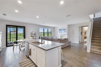 Kitchen with sink, white cabinetry, hardwood / woo