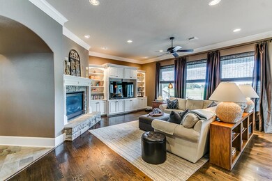 Spacious family room is so inviting! Gleaming wood floors, recessed lighting, crown molding and extra wide baseboards (in every room) & gorgeous wall of windows overlooking your own piece of Friendswood Paradise!