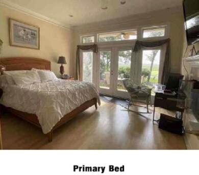 Bedroom featuring french doors, access to exterior, wood finished floors, and ornamental molding