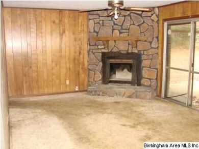 Den with wood burning fireplace, door to fenced ba
