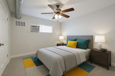 Bedroom with light colored carpet, baseboards, an