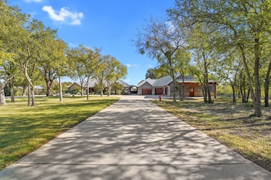 View of front facade with driveway, a front lawn, a garage, and a metal roof