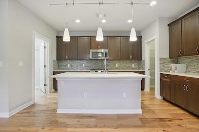 Kitchen with stainless steel microwave, dark brow