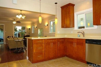 custom lighting and kitchen opens to large living 