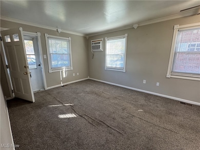Carpeted living room with crown molding and an AC wall unit