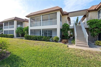 Rear view of property with stairway, a sunroom, a yard, and stucco siding