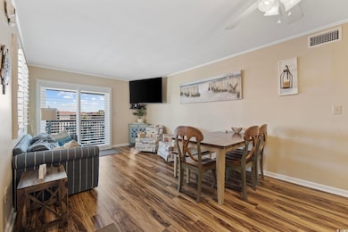 Dining area with wood finished floors, ornamental molding, and a ceiling fan