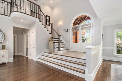Entryway with wood finished floors, stairway, ornamental molding, a high ceiling, and recessed lighting