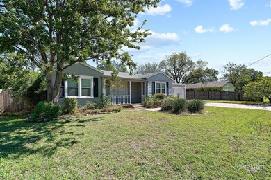 Ranch-style house with covered porch and a front y