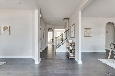 Entrance foyer featuring arched walkways, dark woo