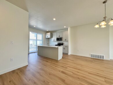 Kitchen with a center island with sink, pendant lighting, open floor plan, recessed lighting, and stainless steel appliances
