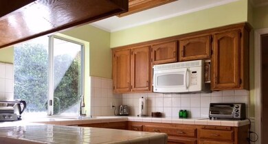 The kitchen is light and bright with morning sun s