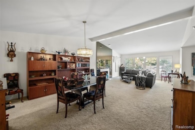 Carpeted dining space with a chandelier