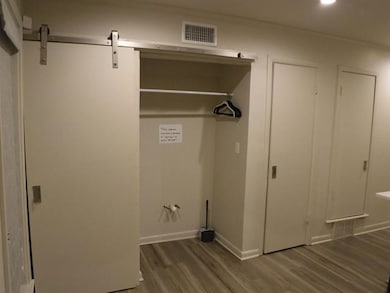 Washroom with wood finished floors, recessed lighting, and a barn door