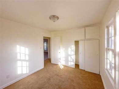 Unfurnished bedroom with light carpet, a closet, and multiple windows