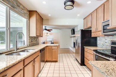 Kitchen with bar area open to Family Rom with Fire