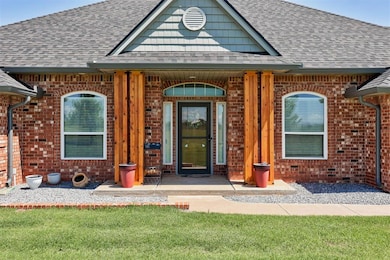 Property entrance featuring roof with shingles, brick siding, and a porch