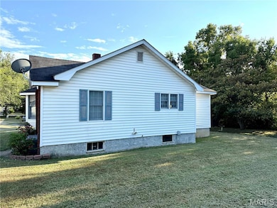 View of side of home with a lawn, a chimney, and roof with shingles