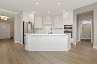 Kitchen featuring white cabinetry, backsplash, cus