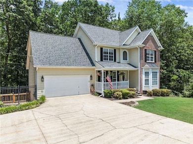 Traditional-style house with covered porch, driveway, an attached garage, and a shingled roof