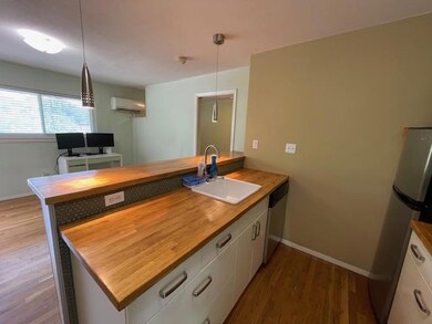 Kitchen featuring wood counters, an AC wall unit,