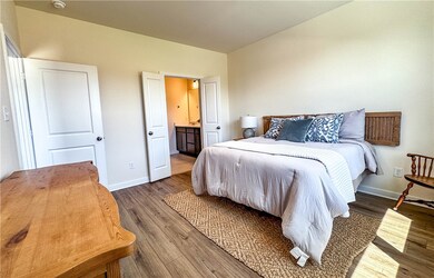 Bedroom featuring ensuite bath, wood finished floo